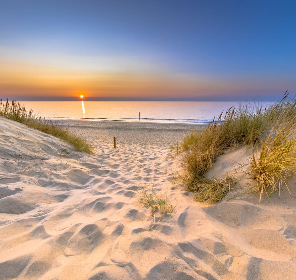Inviting Sunset View over ocean from dune over North Sea and Canal in Ouddorp, Zeeland Province, the Netherlands. Outdoor scene of coast in nature of Europe.
