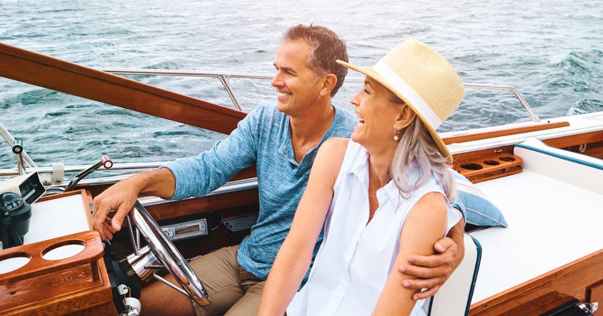 Smiling couple on a boat, representing the lifestyle benefits of early retirement for high earners.