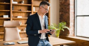High-earning professional reviewing private market investment strategy on tablet in modern office