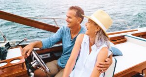 Smiling couple on a boat, representing the lifestyle benefits of early retirement for high earners.