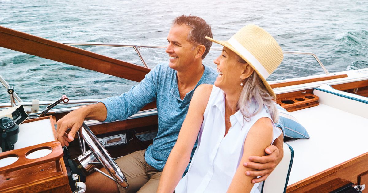 Smiling couple on a boat, representing the lifestyle benefits of early retirement for high earners.