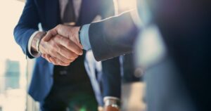 Business professionals shaking hands on a private equity investment decision