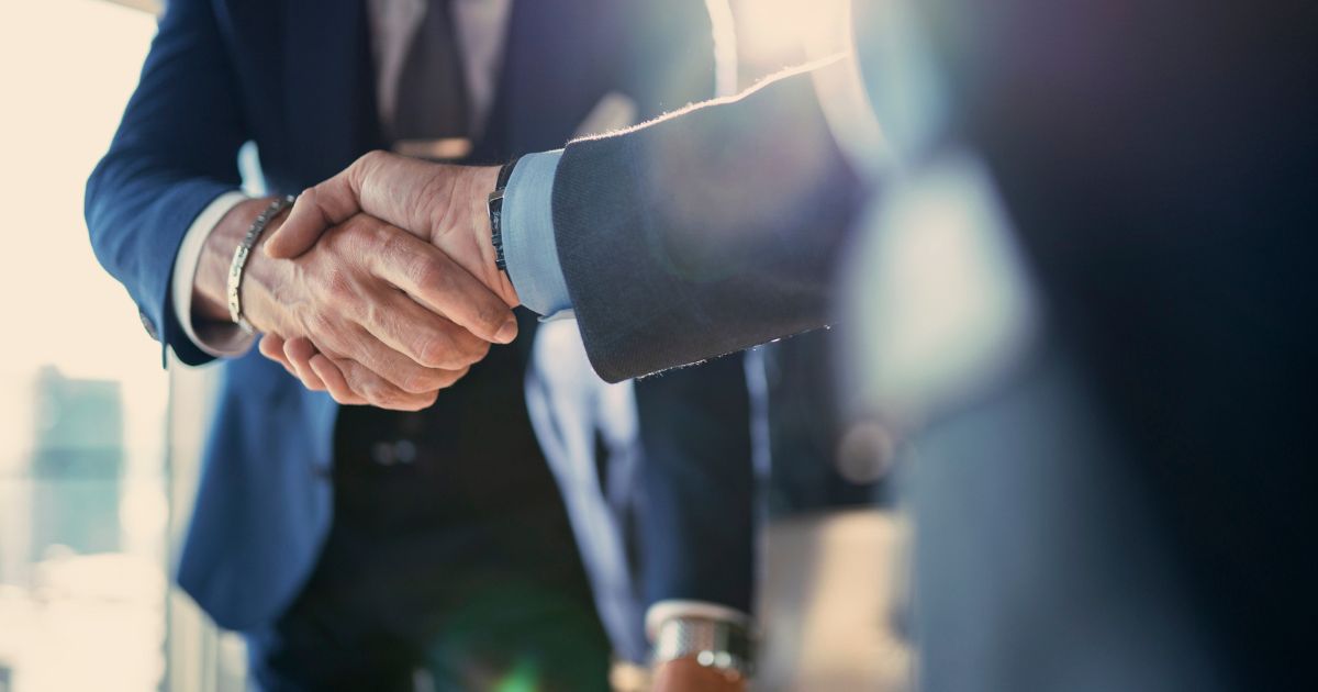 Business professionals shaking hands on a private equity investment decision
