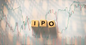 Wooden blocks spelling IPO over a stock price chart, illustrating IPO investing and tax planning