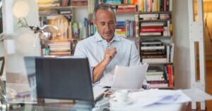High earner reviewing tax-aware investment documents at a home office desk