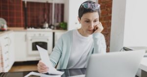 Woman reviewing bills and managing financial anxiety at home