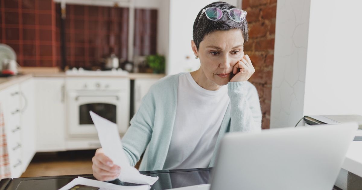 Woman reviewing bills and managing financial anxiety at home